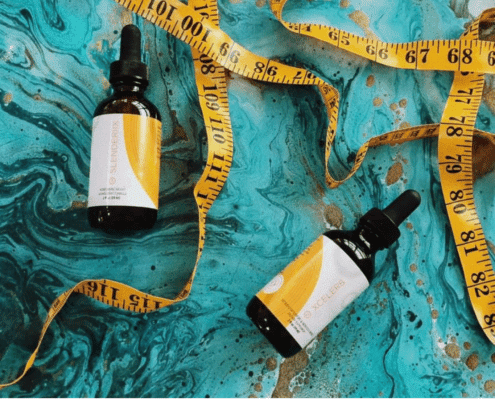 Two bottles of weightloss supplements with a measuring tape