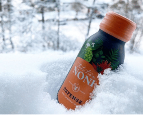 A bottle of Noni Defense supplements placed in the snow